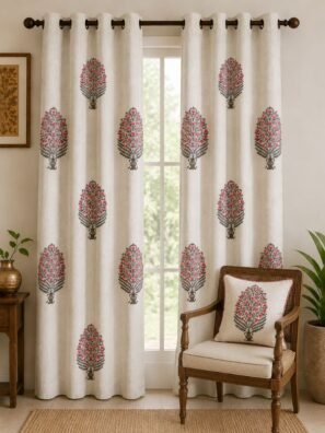 Off-white floral tree print curtain with pink flowers and grey leaves on a living room window, paired with a matching printed cushion on a wooden chair in an elegant Indian home.