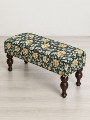 Upholstered bench featuring dark navy fabric with small golden floral prints and green leafy vines.