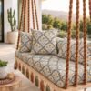 Hanging swing upholstered in ivory fabric with small mustard floral prints, charcoal vines, and taupe leaf patterns.