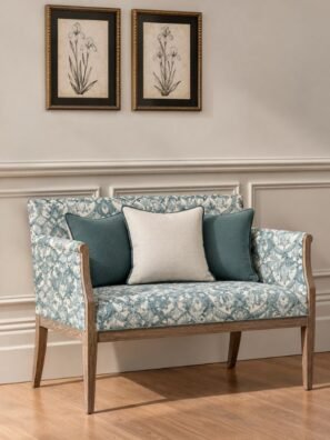 Teal and cream damask upholstery fabric on a classic wooden sofa with contrasting teal cushions.