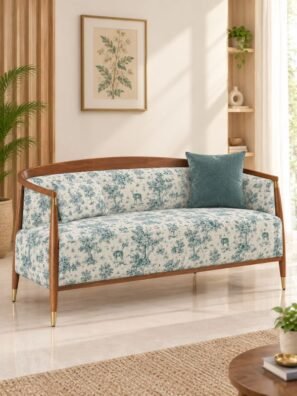 Cream upholstery fabric with a small teal forest print featuring deer, trees, and foliage, beautifully covering a wooden sofa.