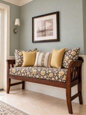 Luxury floral sofa upholstery fabric in charcoal black with golden yellow flowers, cream leaves, and elegant botanical patterns on a wooden sofa by Ruby The Furnishing Studio, Ghatkopar East, Mumbai.