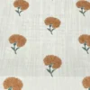 Elegant white sheer curtain with small orange floral prints, displayed on a large arched window in a warm minimalist room.
